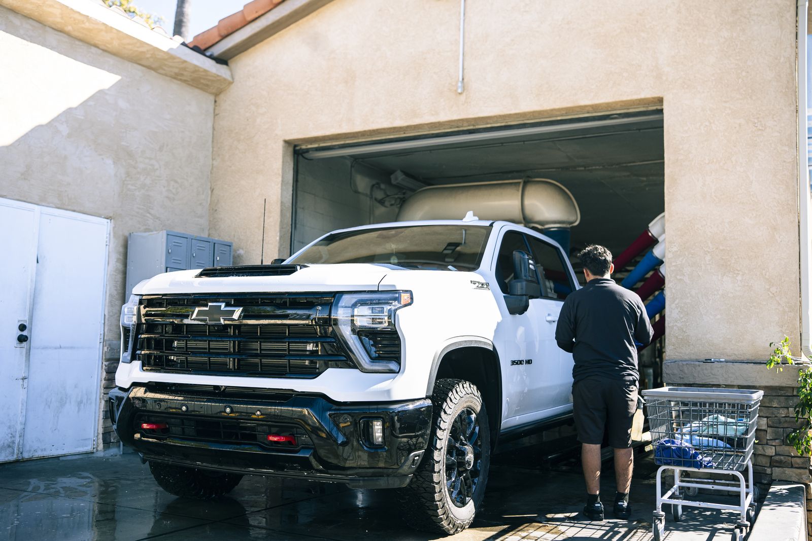 A white Chevrolet truck being hand-washed in the bay