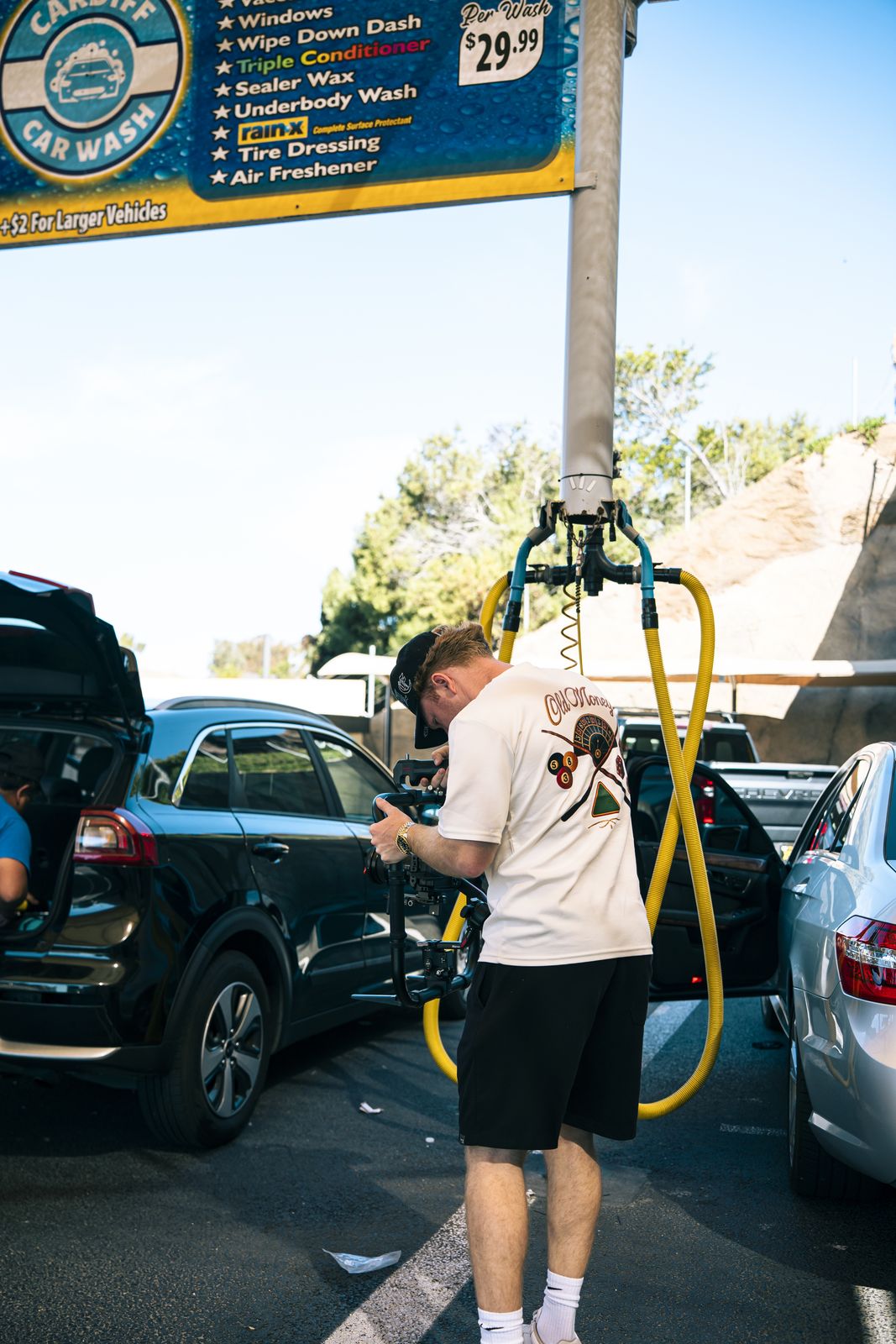 An attendant applying hand foam to a black car