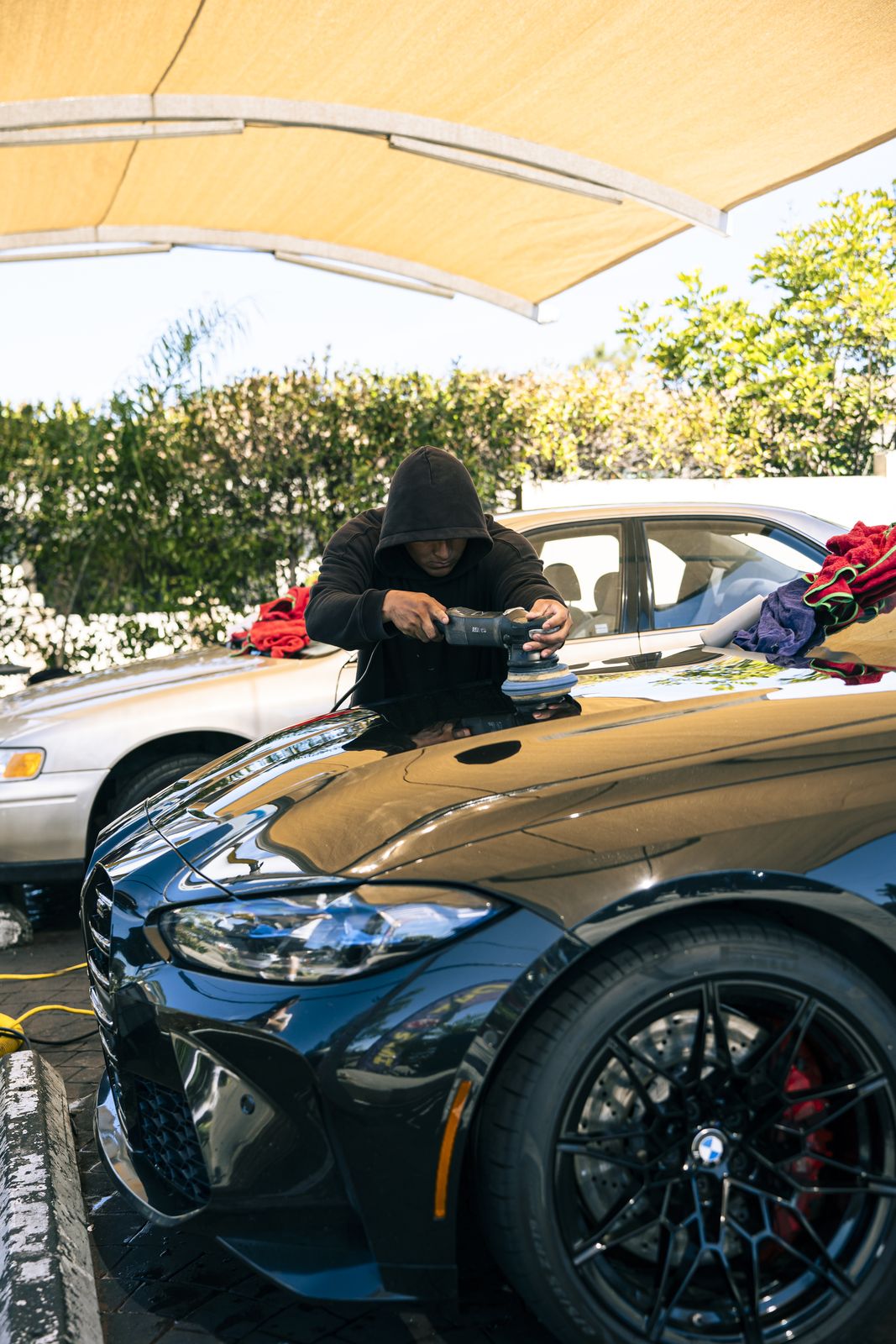 An attendant hand-wiping a black BMW M