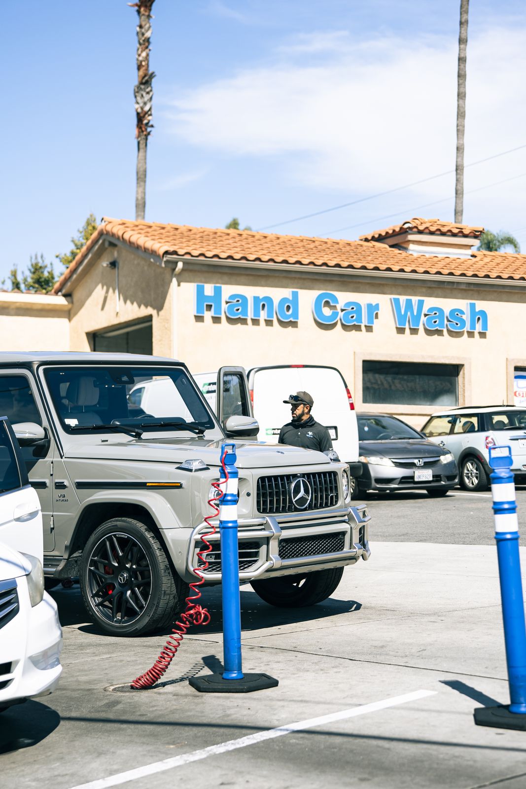 A white Mercedes G-Wagen at the Cardiff Hand Car Wash sign