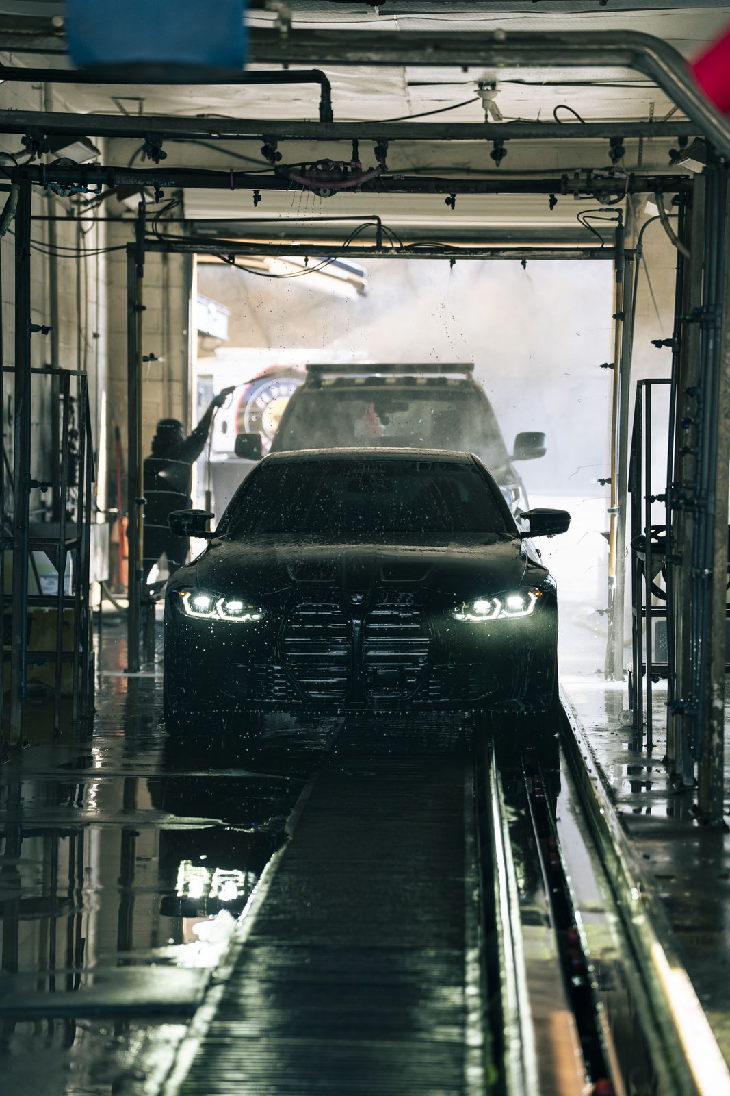 A car on the wash track being hand-washed