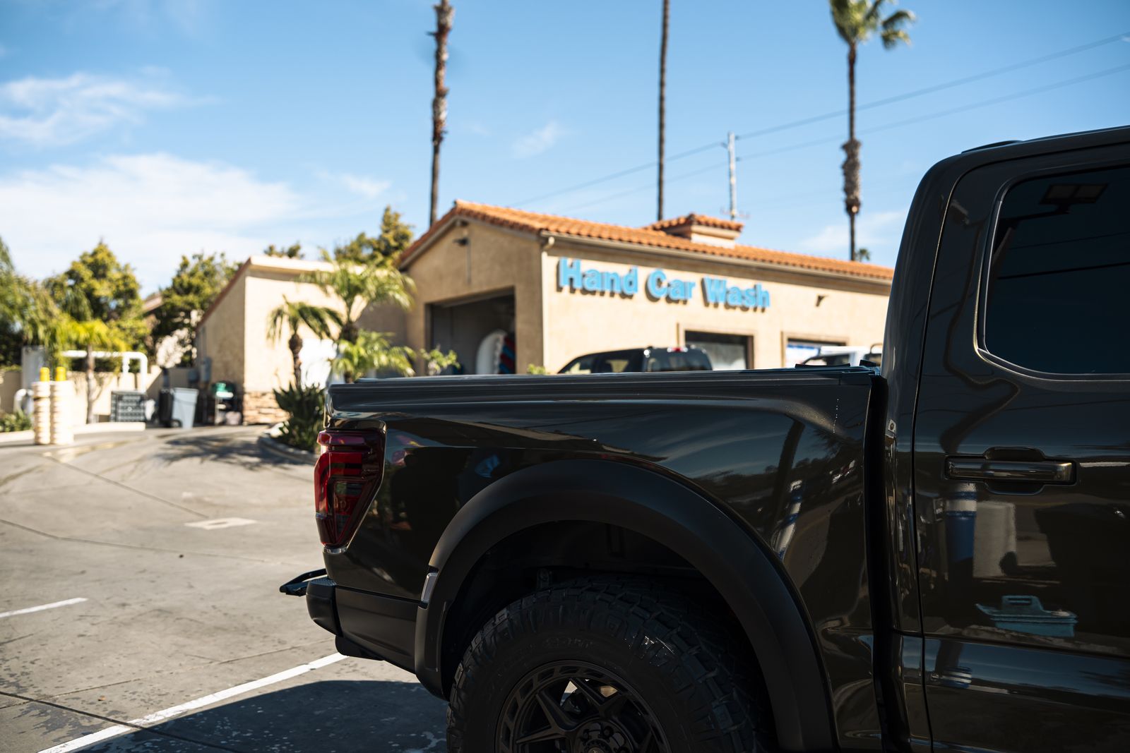 A Ford Raptor beside the Cardiff Hand Car Wash sign