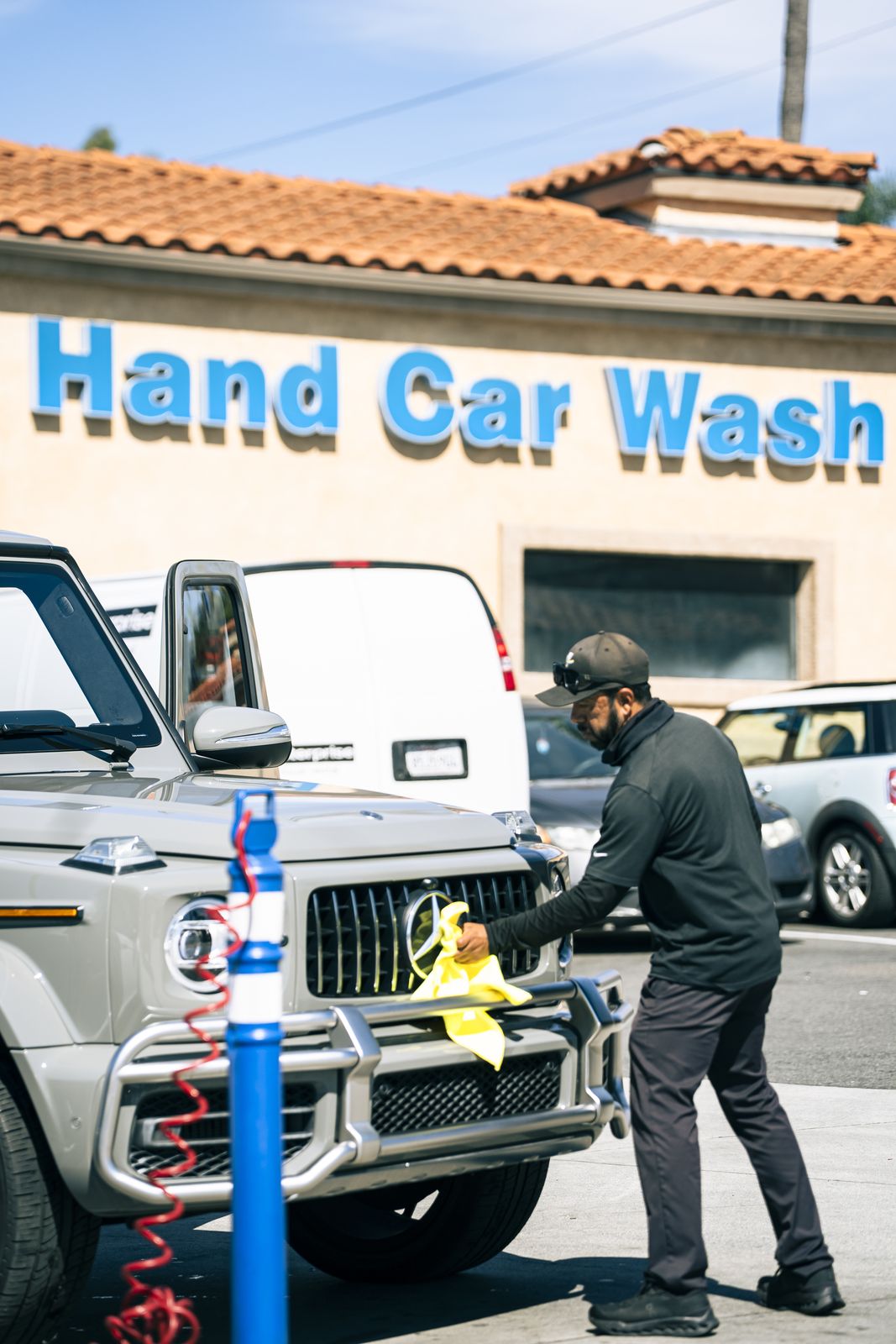 A Mercedes G-Wagen in front of the Cardiff Hand Car Wash sign