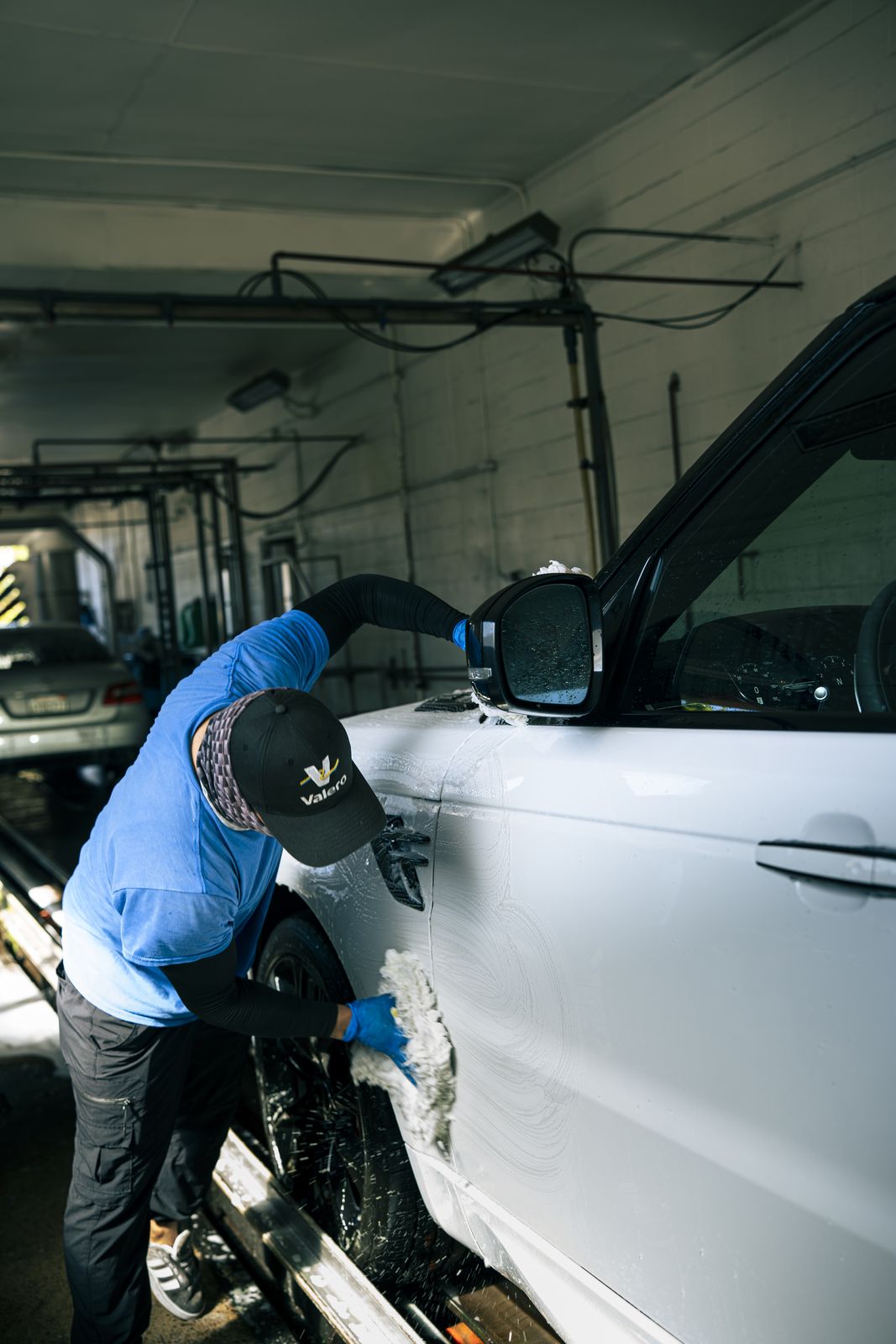 Hand-wiping the fender of a white car